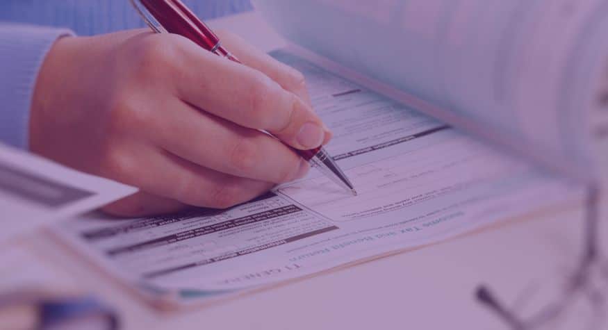 Main d'une personne qui effectue ses impôts