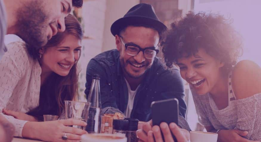 Groupe d'amis qui regarde l'écran d'un cellulaire